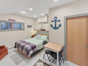 a bedroom with a bed and a table and a desk at Quietside Studio - Fire Pit - Near Acadia in Southwest Harbor