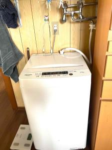 a white refrigerator in a kitchen with a sink at Nomad Gala Otaru in Otaru