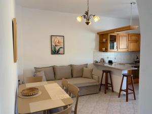 a living room and kitchen with a couch and a table at Bernie House in Mélanes