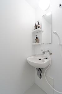 a white bathroom with a sink and a mirror at アンドステイ屋形町704 in Kyoto +31 photos