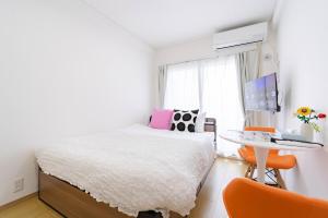 a bedroom with a bed and a desk and a table at アンドステイ屋形町704 in Kyoto