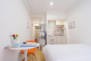 a room with a bed and a table and a kitchen at アンドステイ屋形町704 in Kyoto