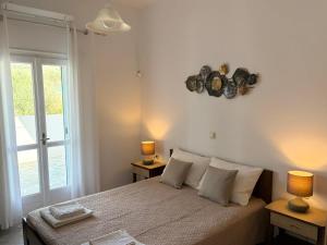 a bedroom with a bed with two lamps and a window at Bernie House in Mélanes