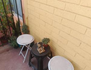 two tables and two stools sitting next to a wall at La Nave Coquimbo in Coquimbo