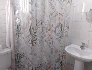 a bathroom with a shower curtain and a sink at La Nave Coquimbo in Coquimbo