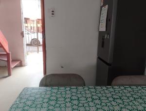 a kitchen with a table and two chairs and a refrigerator at La Nave Coquimbo in Coquimbo