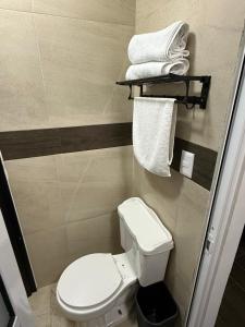 a small bathroom with a white toilet and towels at Casa Legado in Orizaba