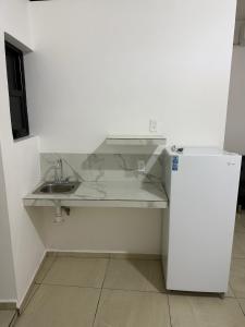 a white kitchen with a sink and a refrigerator at Casa Legado in Orizaba