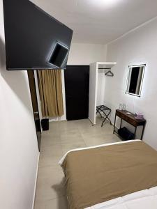 a bedroom with a bed and a table and a television at Casa Legado in Orizaba
