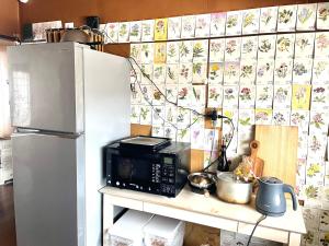 a kitchen with a microwave and a refrigerator at Nomad Gala Otaru in Otaru