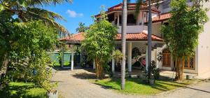 a house with palm trees in front of it at Winter Palace Lakeside in Embilipitiya