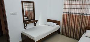 a small room with a mirror and two beds at Winter Palace Lakeside in Embilipitiya
