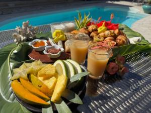 a tray of food on a table with fruit and juice at Relais Fenua in Punaauia