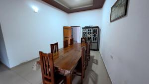 a dining room with a wooden table and chairs at Winter Palace Lakeside in Embilipitiya