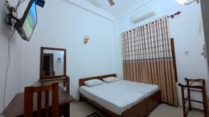 a bedroom with a bed and a mirror and a chair at Winter Palace Lakeside in Embilipitiya