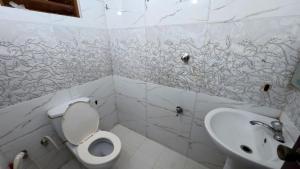 a white bathroom with a toilet and a sink at Winter Palace Lakeside in Embilipitiya +27 photos