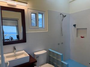 a bathroom with a toilet and a sink and a mirror at Tranquility Bay Beach Retreat in Trujillo +58 photos
