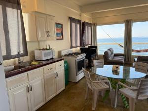 a kitchen with a table and a dining room with a view at Tranquility Bay Beach Retreat in Trujillo