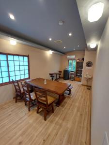 a dining room with a wooden table and chairs at ゲストハウス凪季のやど in Nachikatsuura