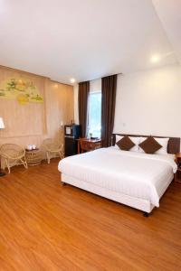 a bedroom with a large white bed and wooden floors at Êm Villa 8 Bedrooms with Swimming Pool in Hue +42 photos