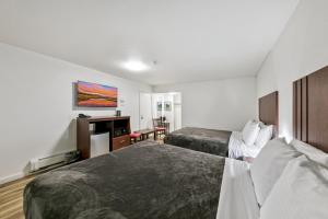 a hotel room with two beds and a desk at Ambassador Lake Tahoe in South Lake Tahoe