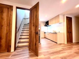 a hallway with a staircase in a house at The Lobs Five, Brand New, 4 bedroom, 3 bath, 4 toilet, 8 min to Rusutsu, 7-11, bus at door in Kimobetsu