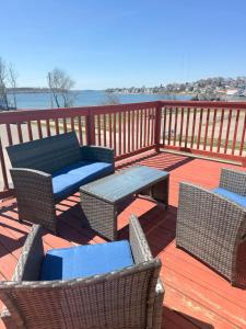 a deck with wicker chairs and a table and chairs at Ocean View Cozy Stay 4 in Hull