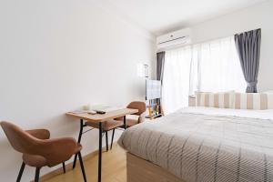 a bedroom with a bed and a table and chairs at アンドステイ屋形町507 in Kyoto
