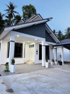 a white and blue house with a driveway at NY VILLA Homestay in Kota Bharu