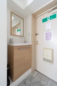 a bathroom with a sink and a mirror at アンドステイ屋形町507 in Kyoto +31 photos