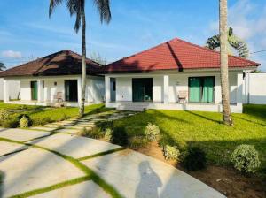 a house with a red roof and a yard at villa zoum in Assinie