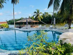 a swimming pool at a resort with a gazebo at villa zoum in Assinie