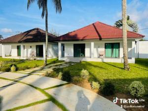 a white house with a red roof and palm trees at villa zoum in Assinie