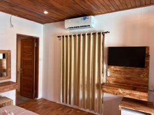 a living room with a television and a radiator at Villa lumbung sari in Cemagi