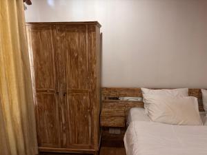 a bedroom with a wooden cabinet next to a bed at Villa lumbung sari in Cemagi +19 photos