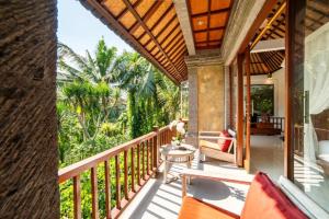 a balcony of a house with a view of the jungle at Akamana Villa Ubud in Ubud