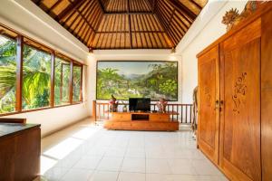a living room with a large painting on the wall at Akamana Villa Ubud in Ubud