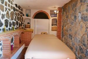a bed in a room with a brick wall at Wellness Pet Friendly El Secreto in Tepoztlán