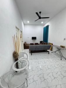 a living room with a couch and chairs at NY VILLA Homestay in Kota Bharu +12 photos
