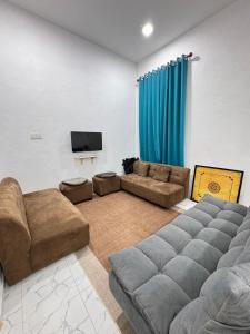 a living room with a couch and a tv at NY VILLA Homestay in Kota Bharu
