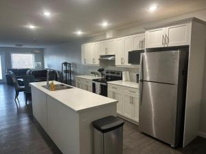a kitchen with white cabinets and a stainless steel refrigerator at Home Away from Home in Brandon