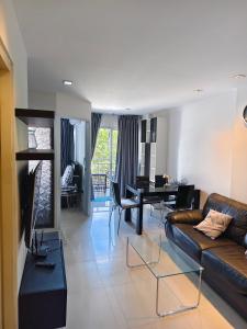 a living room with a couch and a table at Mosaic Condminum A24m by malai in Mae Pim
