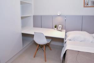 a white desk in a bedroom with a bed and a chair at Comfy Apt w Pool & Coworking in Fernando de la Mora