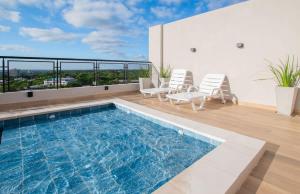 a swimming pool on the roof of a building with chairs at Comfy Apt w Pool & Coworking in Fernando de la Mora +15 photos