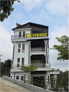a large white building with a yellow sign on it at Mộc View House in Mộc Châu +10 photos