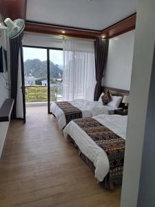 a hotel room with two beds and a large window at Mộc View House in Mộc Châu