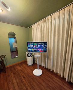 a room with a computer monitor and a window at Gangneung Wheel Hotel in Gangneung