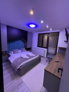 a bedroom with a large bed and a desk at Apartament André in Sibiu