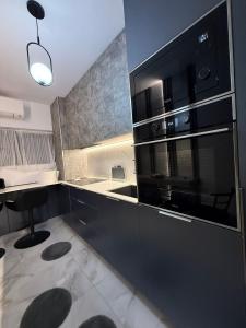 a kitchen with a large black microwave and a stool at Apartament André in Sibiu +6 photos