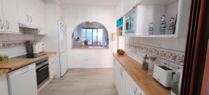 a kitchen with white cabinets and white appliances at Beautiful house with ocean views in La Cala de Mijas
